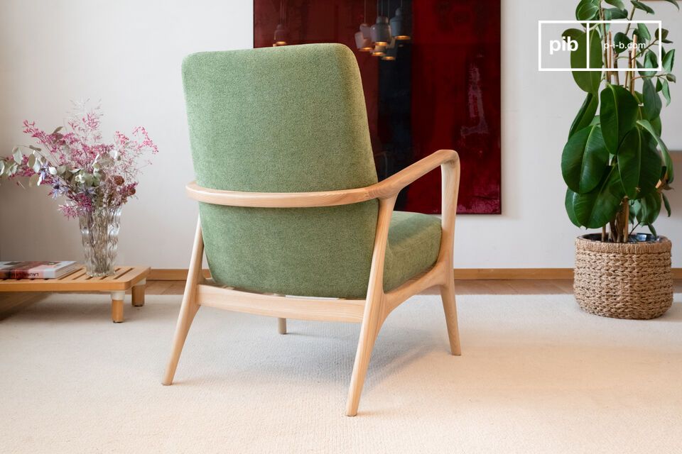 Ce fauteuil présente un design aux lignes courbes et une structure en bois clair